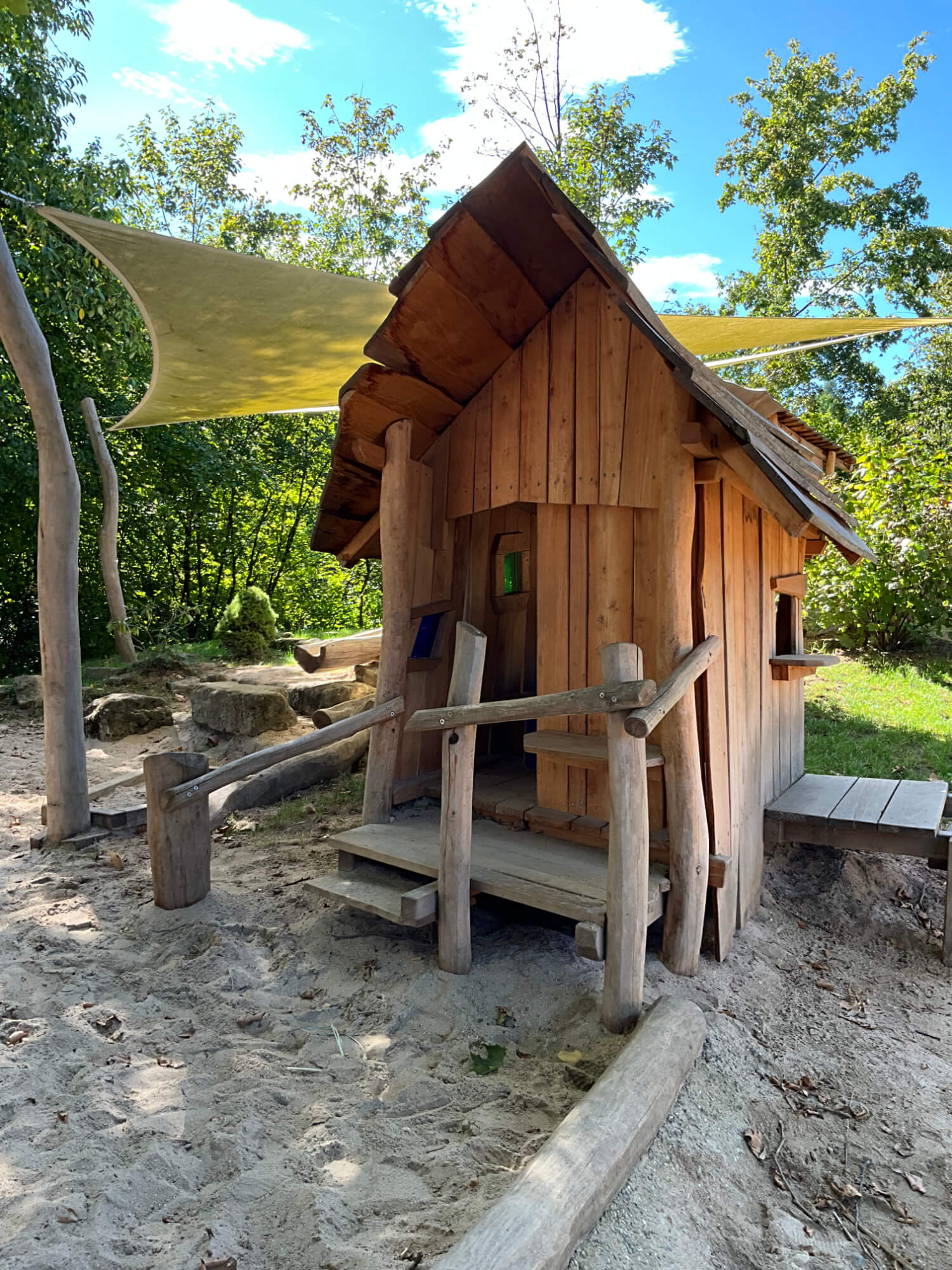 Ein kleines Holzhaus im Sand.
