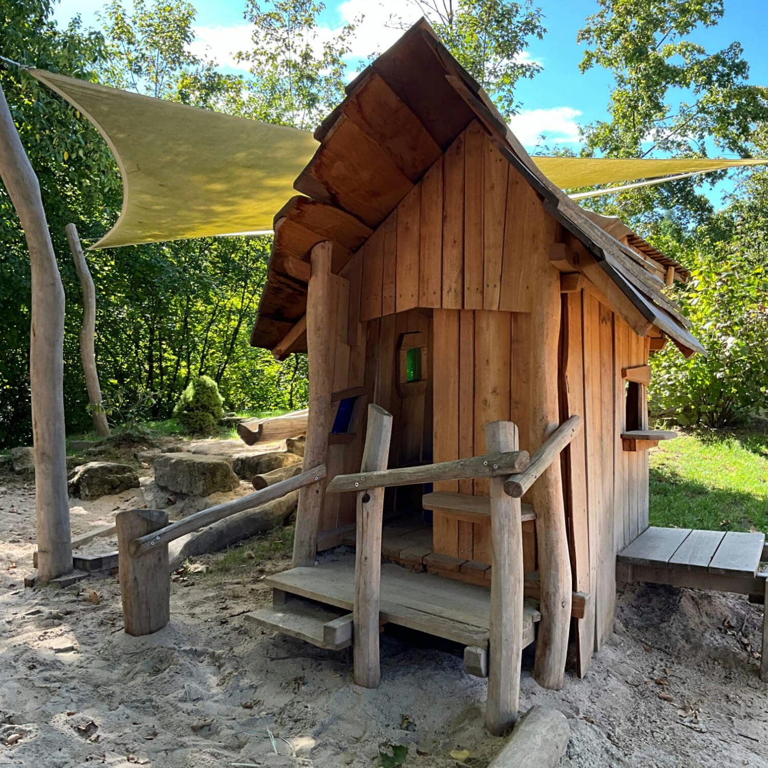 Ein kleines Holzhaus im Sand.