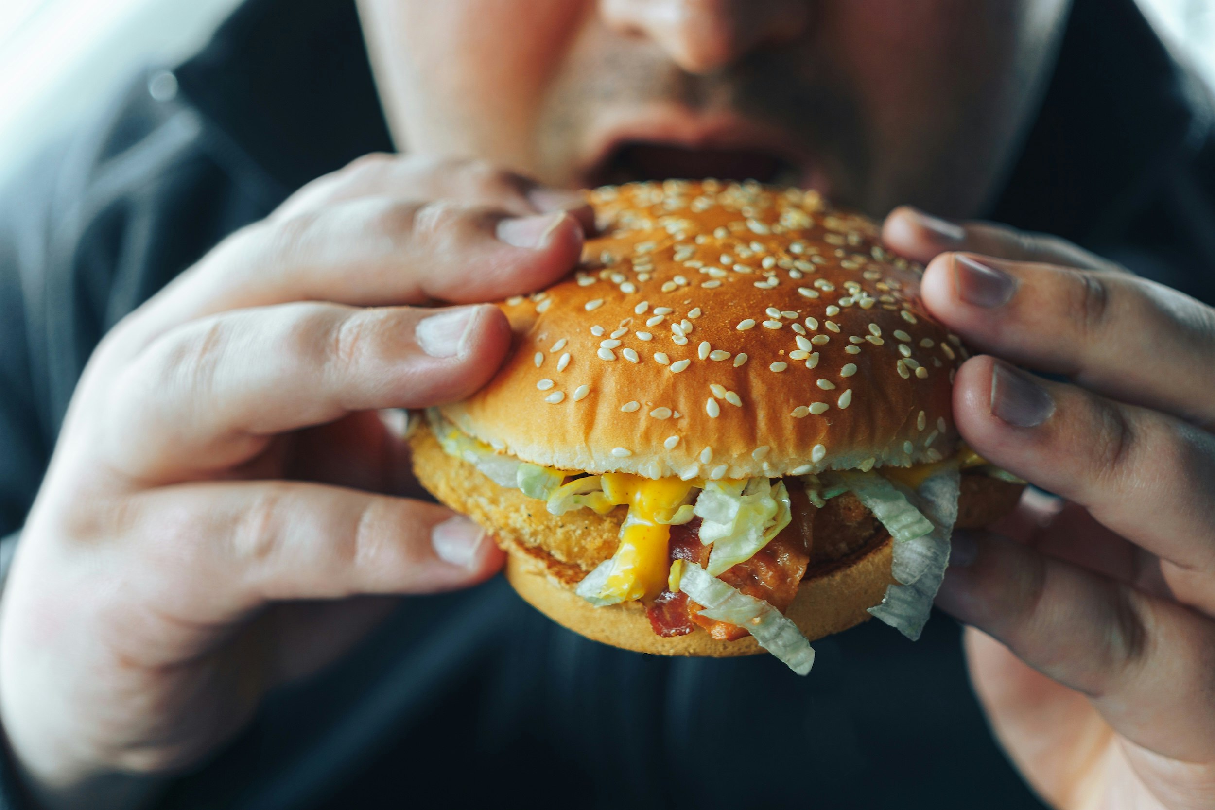 Mand spiser burger