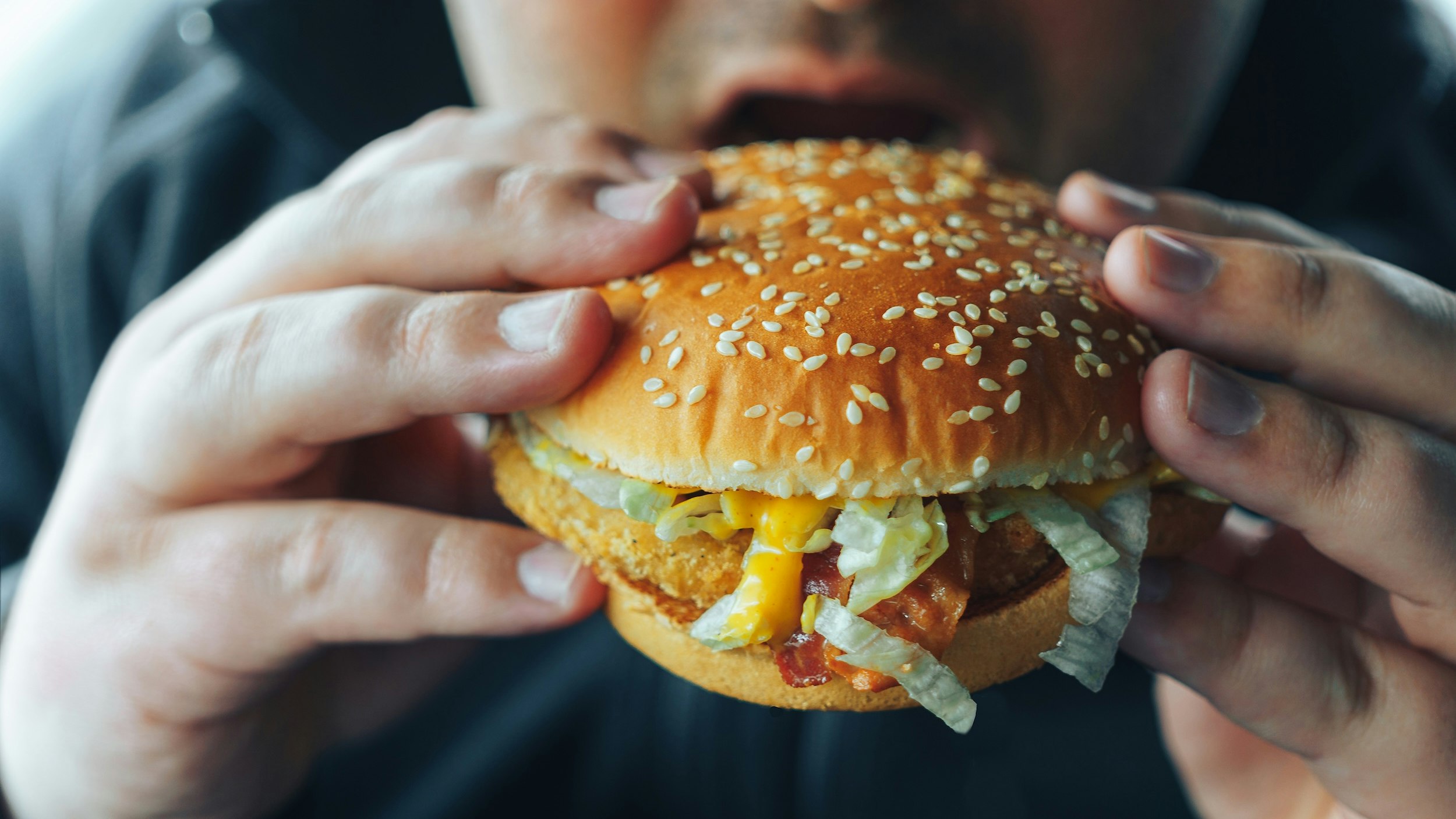Mand spiser burger