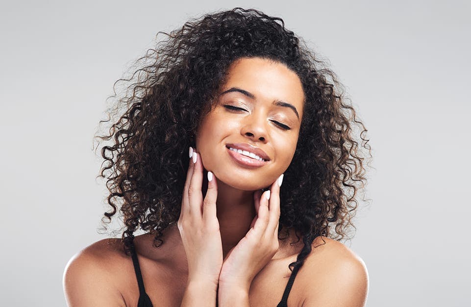 Woman With Her Eyes Closed and Her Hands on Her Cheeks