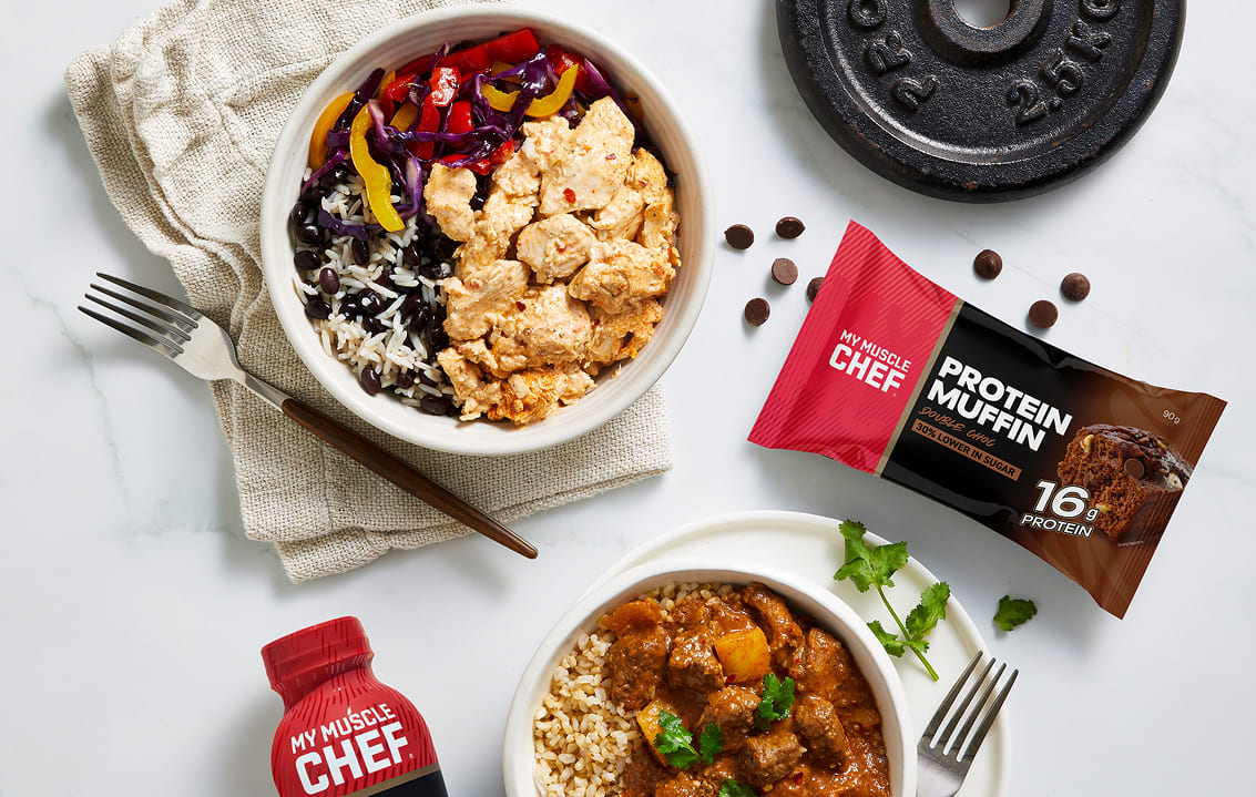 Man enjoying a healthy meal with chicken, broccoli, and sweet potatoes, alongside a My Muscle Chef meal package.