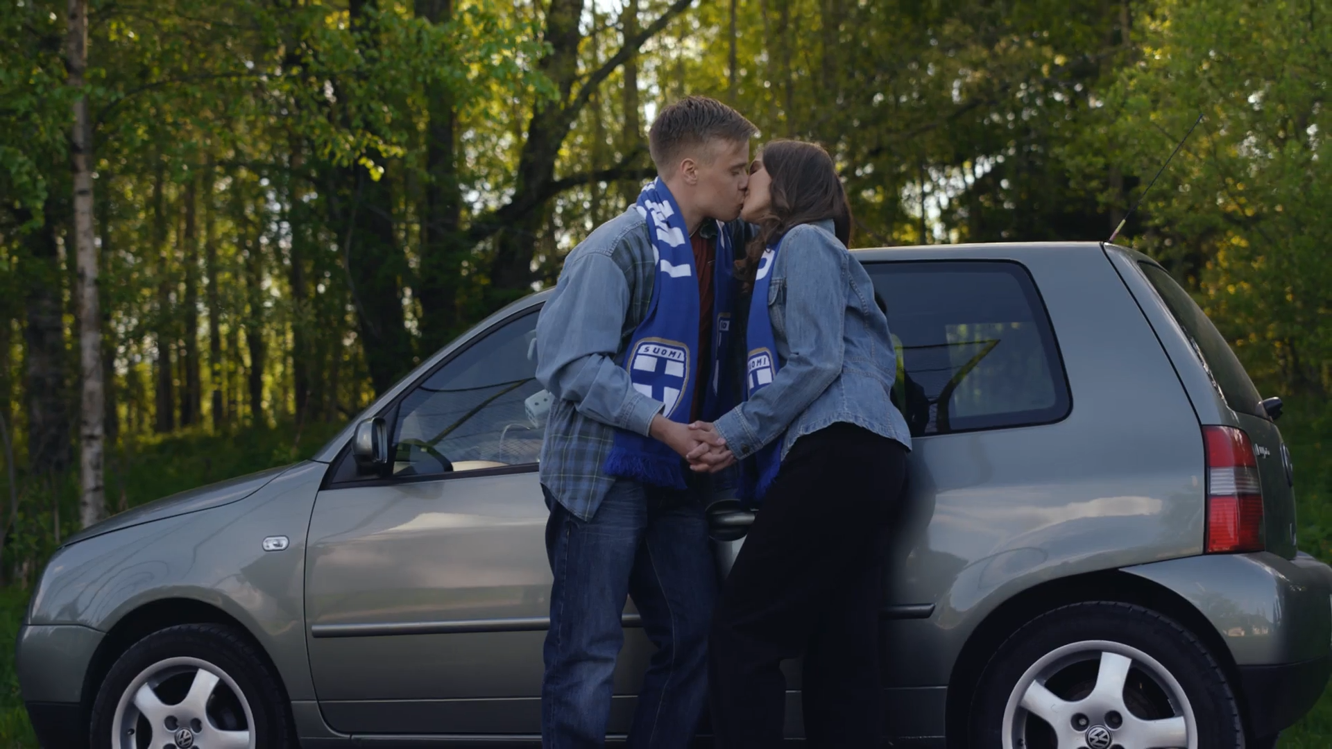 couple kissing in front of Volkswagen Golf