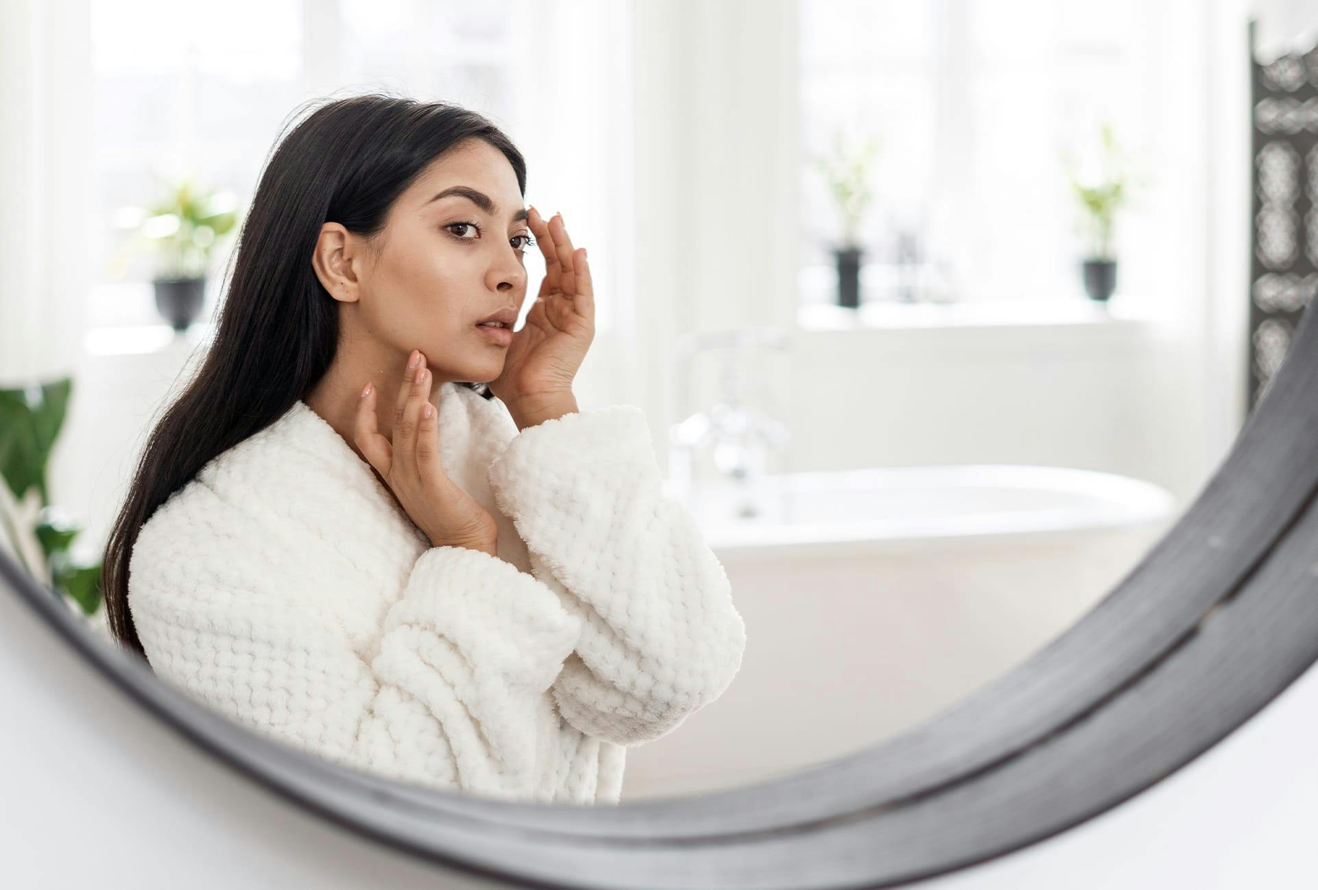 Woman looking at her Face in the Mirror