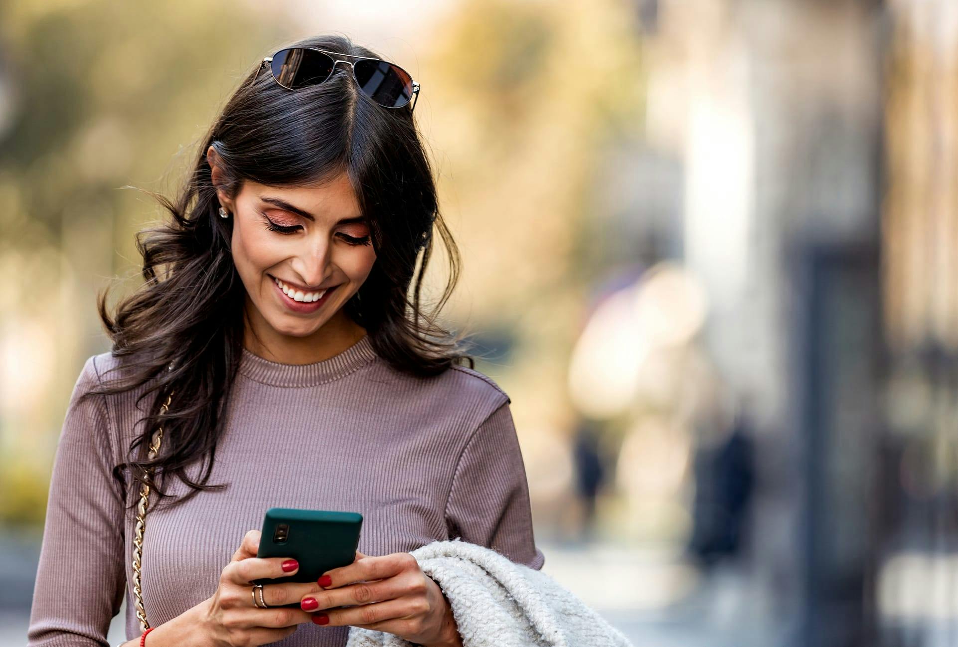 Woman Smiling looking at her Phone