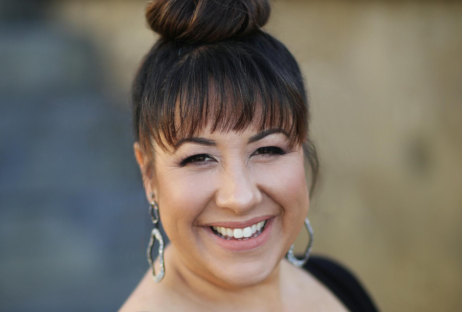 Woman with a Bun and Bangs Smiling