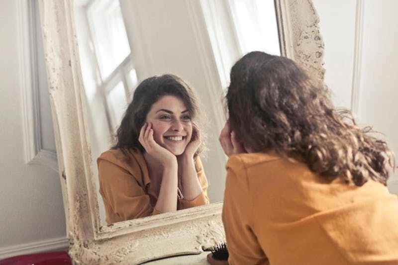Woman smiling in the mirror.