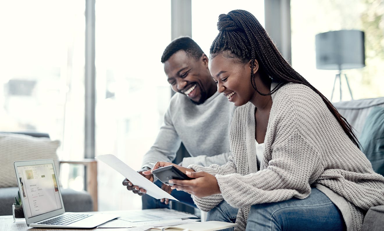 Couple Sitting at a Coffee Table looking at Papers