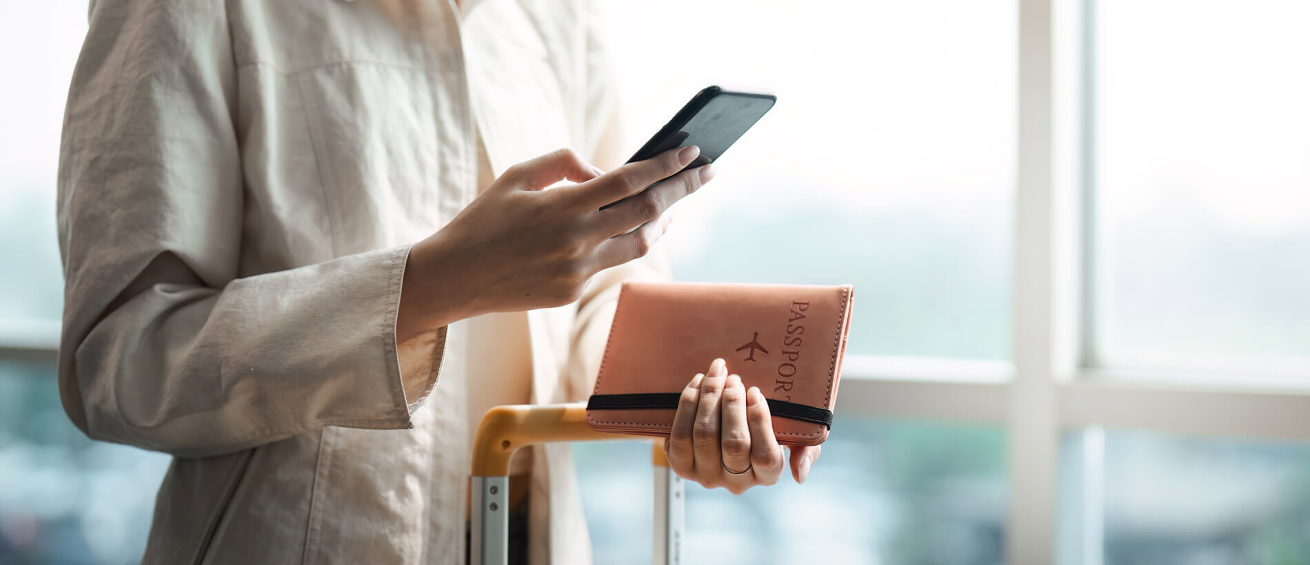 woman in airport with smartphone and passport