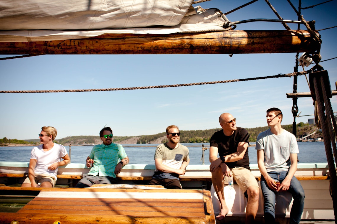 4 developers and a project manager on a ship enjoying the sun