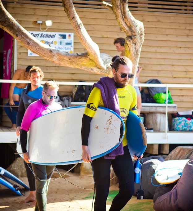 Two developers carrying 2 surfboards