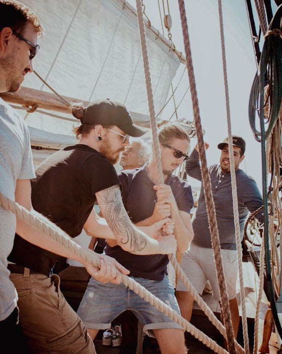 Teamet anstränger sig med att dra i rep i en båt.
