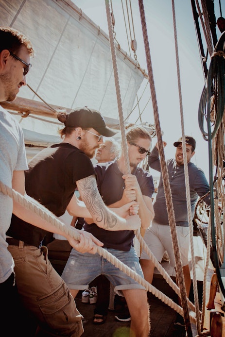 The team is pulling the rope on a boat with effort