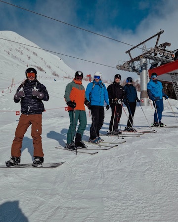 Kollegor som står i skidbacken