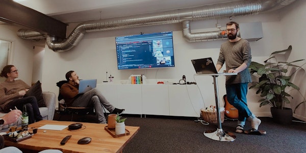 André som står vid ett podium medan andra lyssnar.