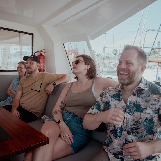 Weahead colleagues sitting in a boat, talking and laughing