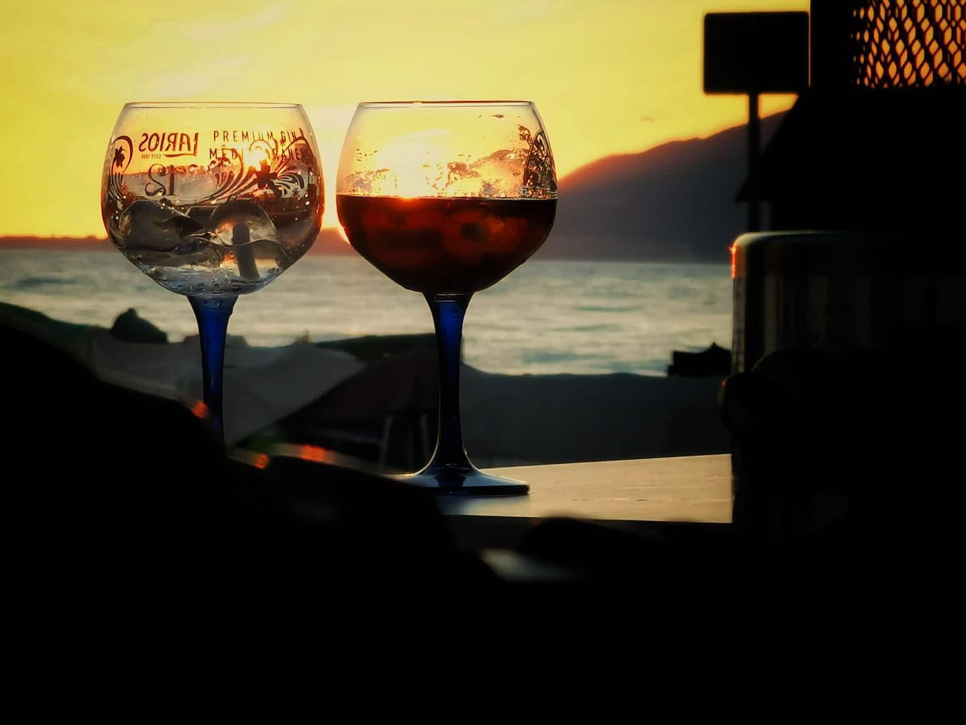 Foto de copas frente a un atardecer en el mar