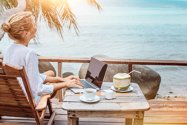 Mujer trabajando con su portatil en la playa