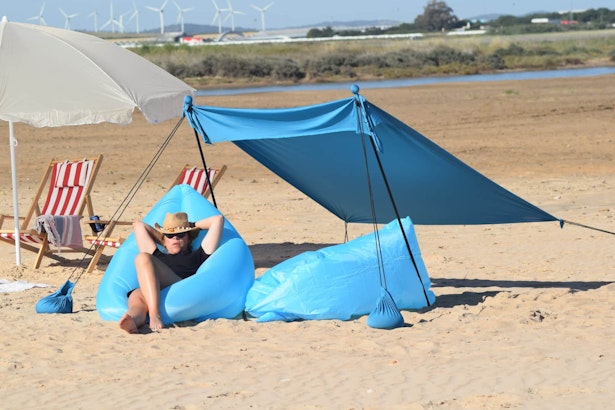 mujer tumbada en una tumbona hinchable en la playa