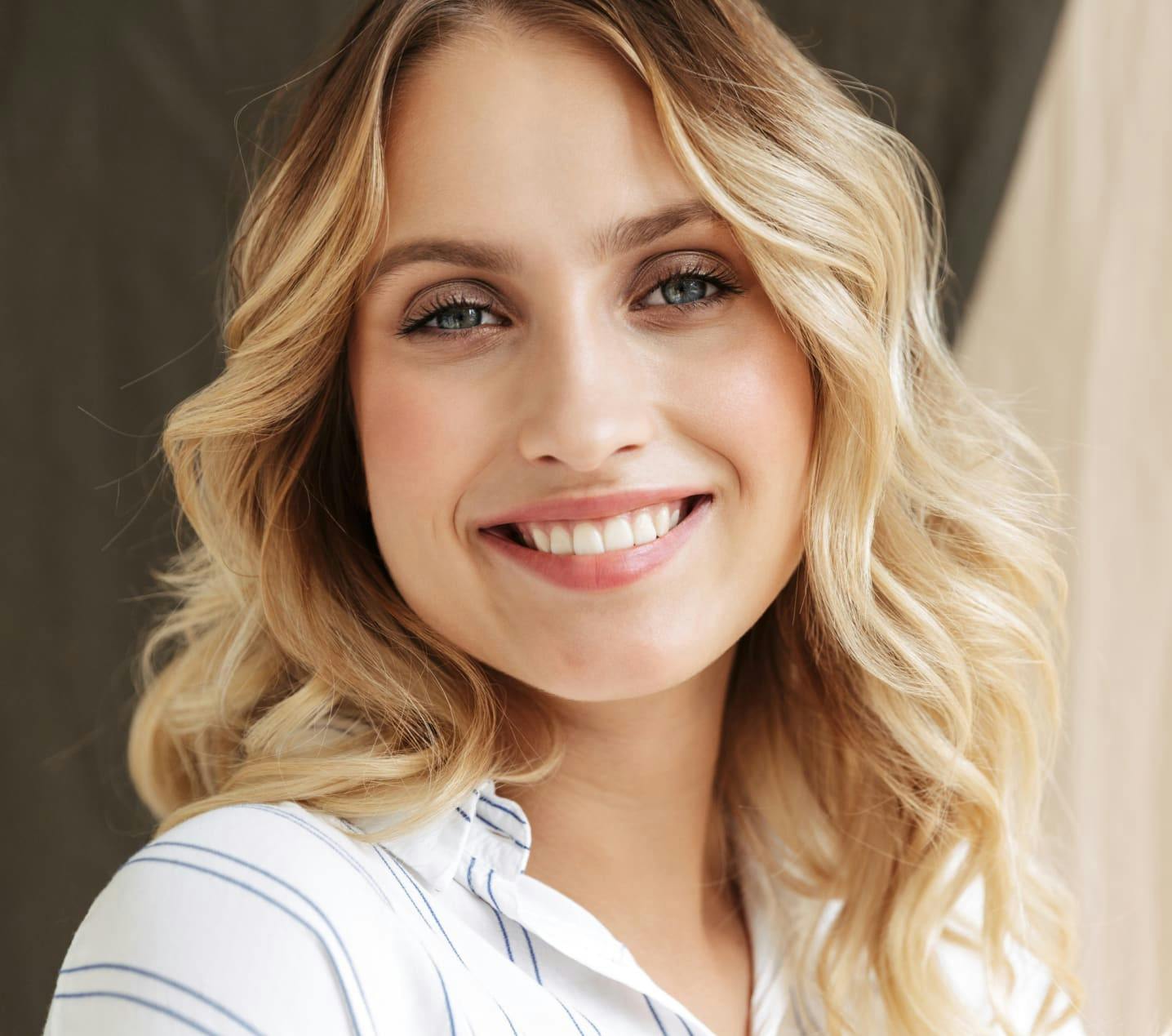 Woman with curly blonde hair smiling