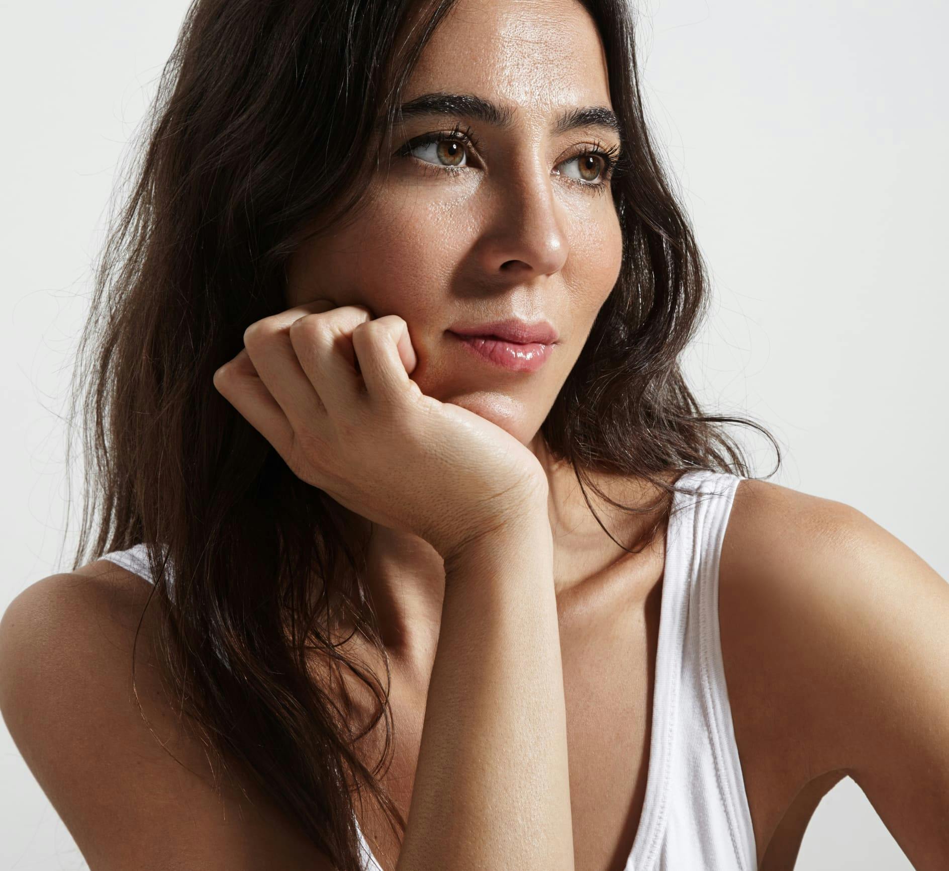 Woman looking to the side while resting her chin on her hand