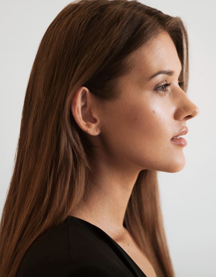 Woman with long auburn hair facing to the right