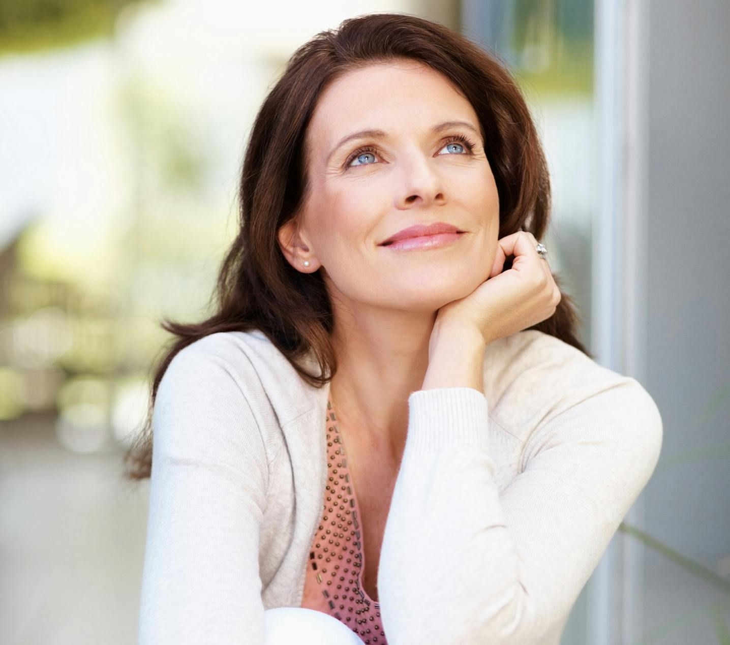 Woman looking upwards with her face resting on her hand