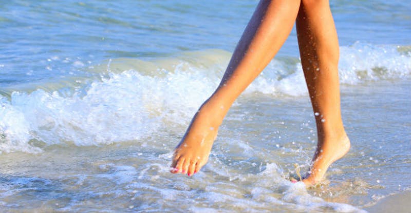 woman's feet in the ocean