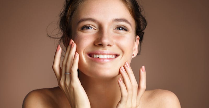 smiling woman with hands on face and cheeks