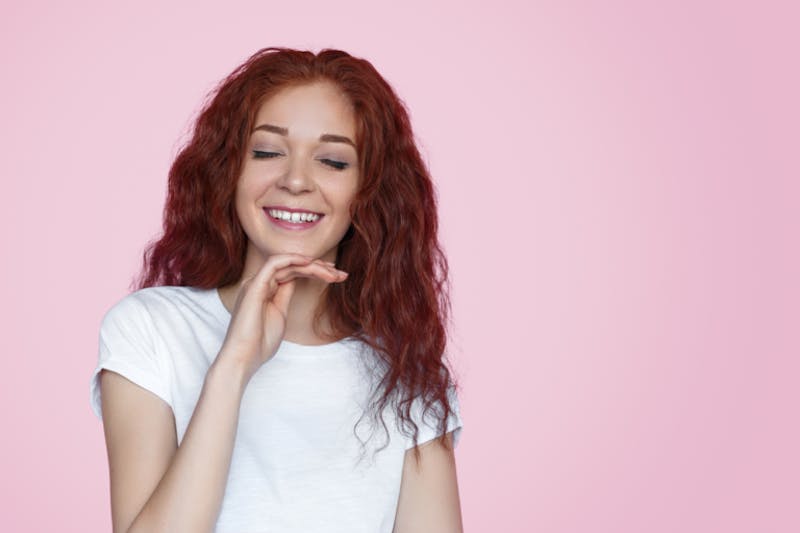 woman with red hair wearing a white top