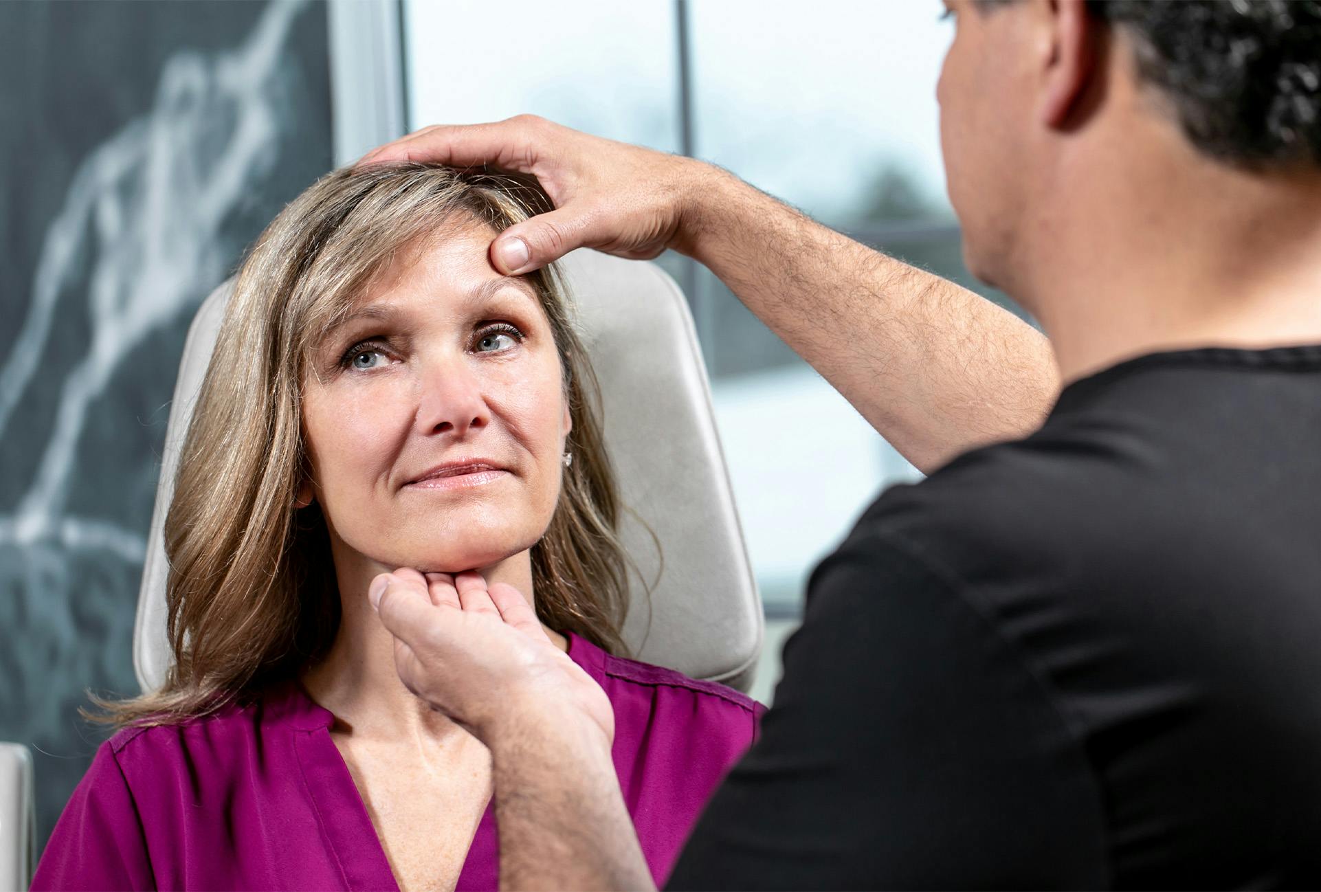 Doctor inspecting woman's face