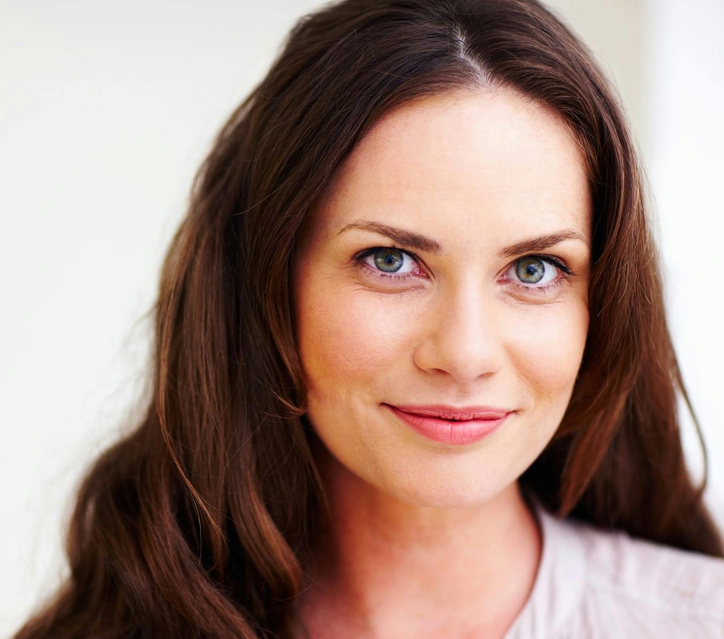 Woman with auburn hair smirking