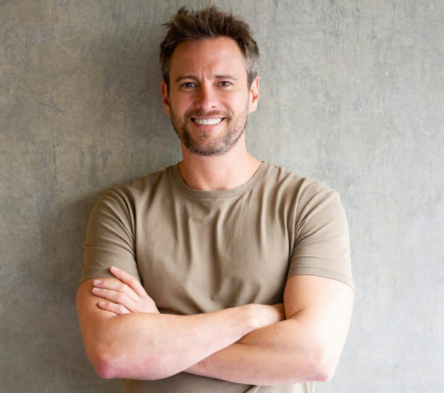 Man smiling with his arms crossed