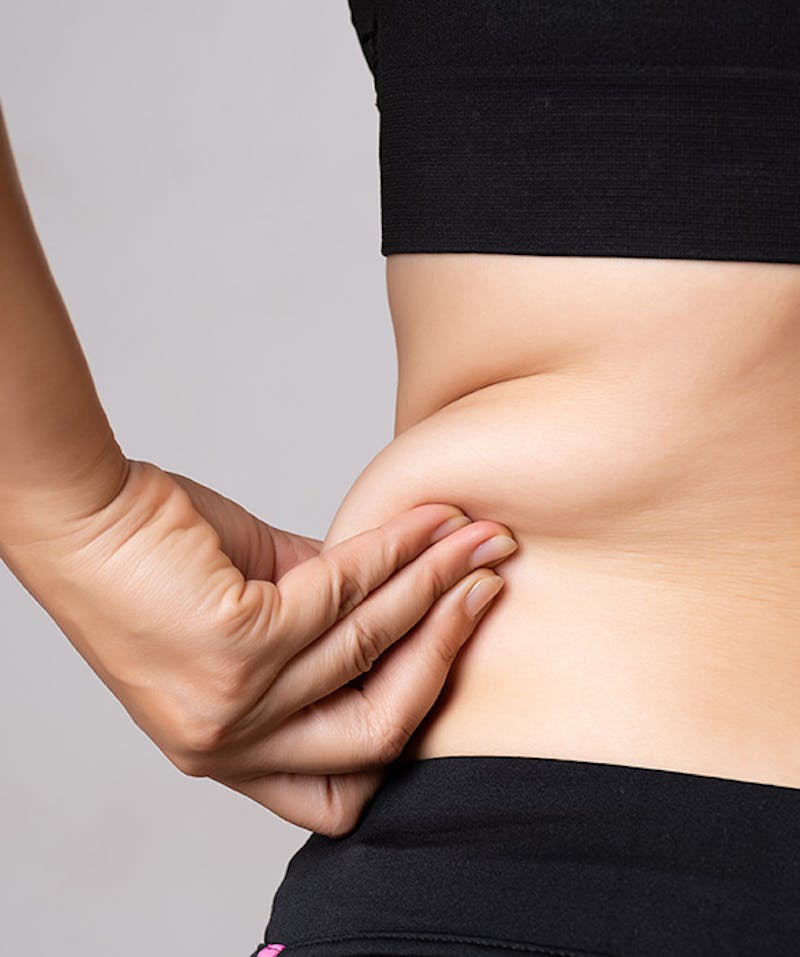 A woman grabbing her love handles