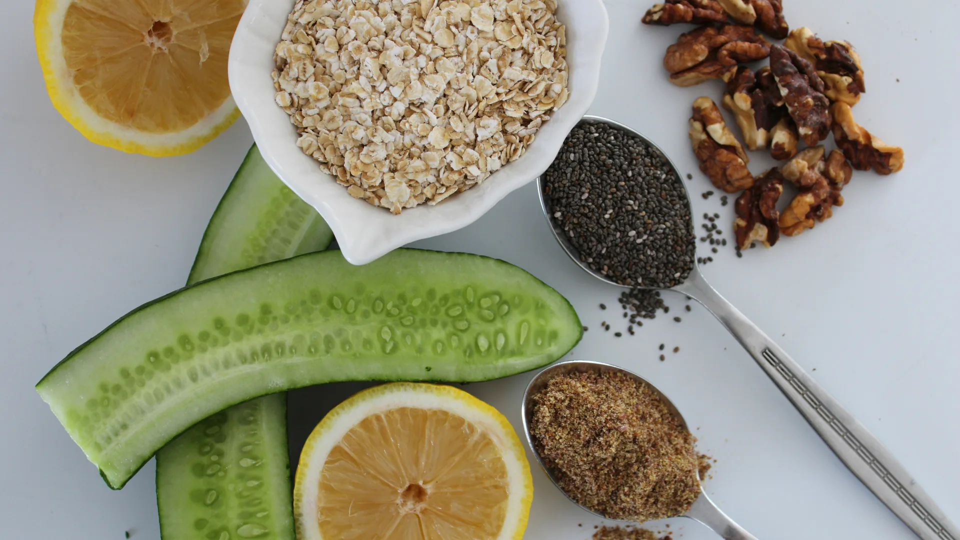 Gezonde orthomoleculaire ingrediënten zoals havermout, komkommer, citroen, chiazaad, lijnzaad en walnoten — rijk aan vezels, omega-3 en antioxidanten voor een gebalanceerd dieet.