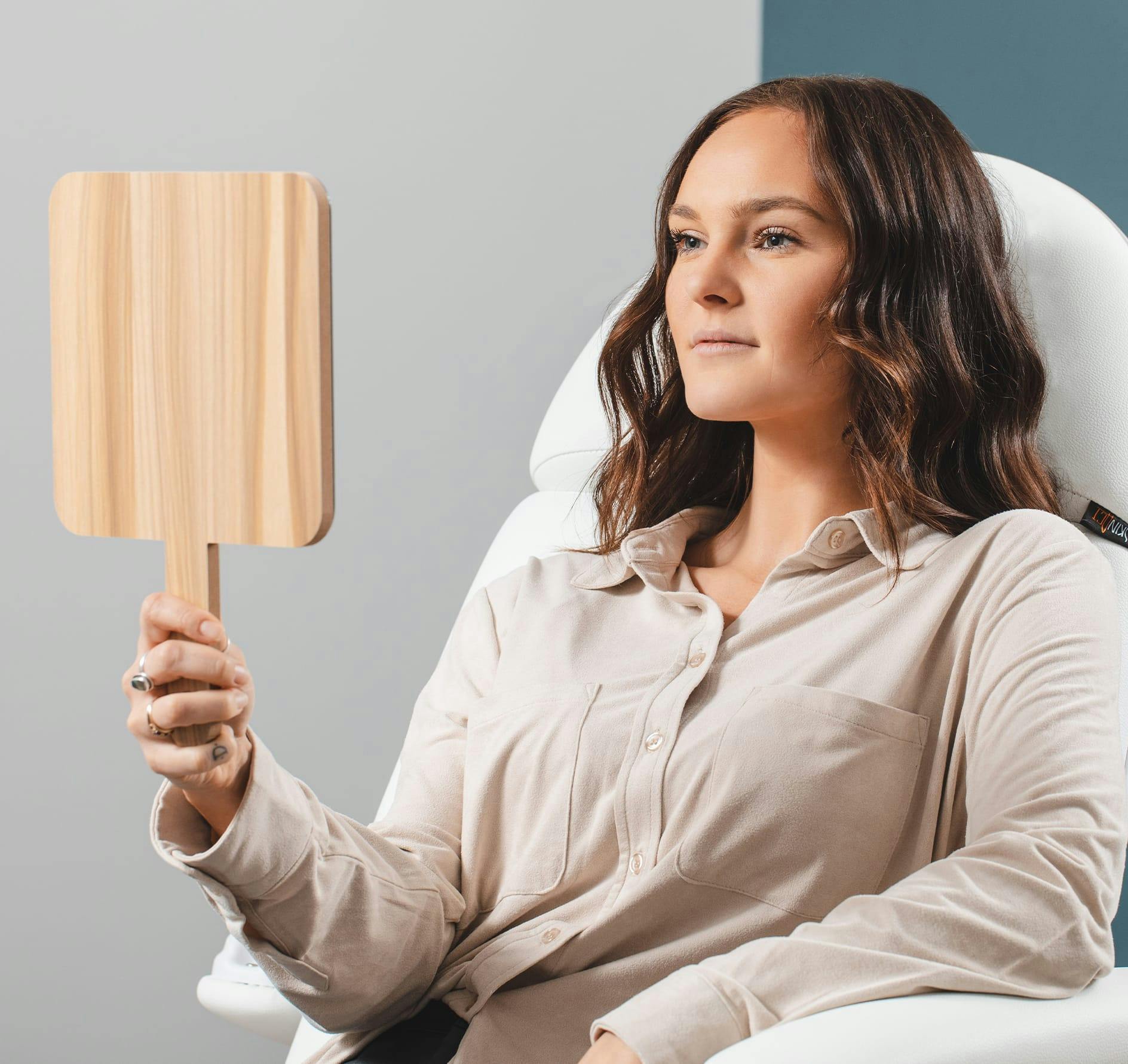 Woman Looking in a Handheld Mirror