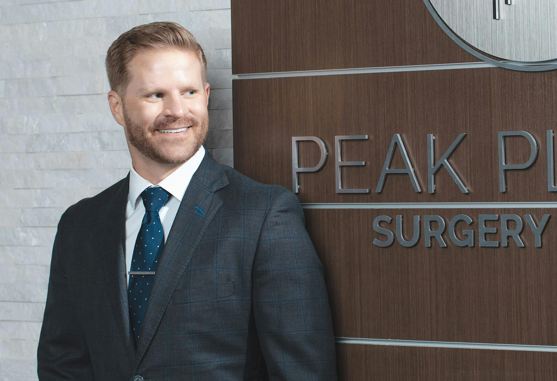 Dr. Garrett Locketz In Front of the Peak Plastic Surgery Sign