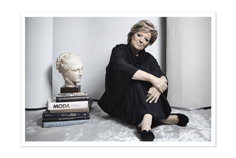 Annamaria Cammilli next to high education books and a sculpture