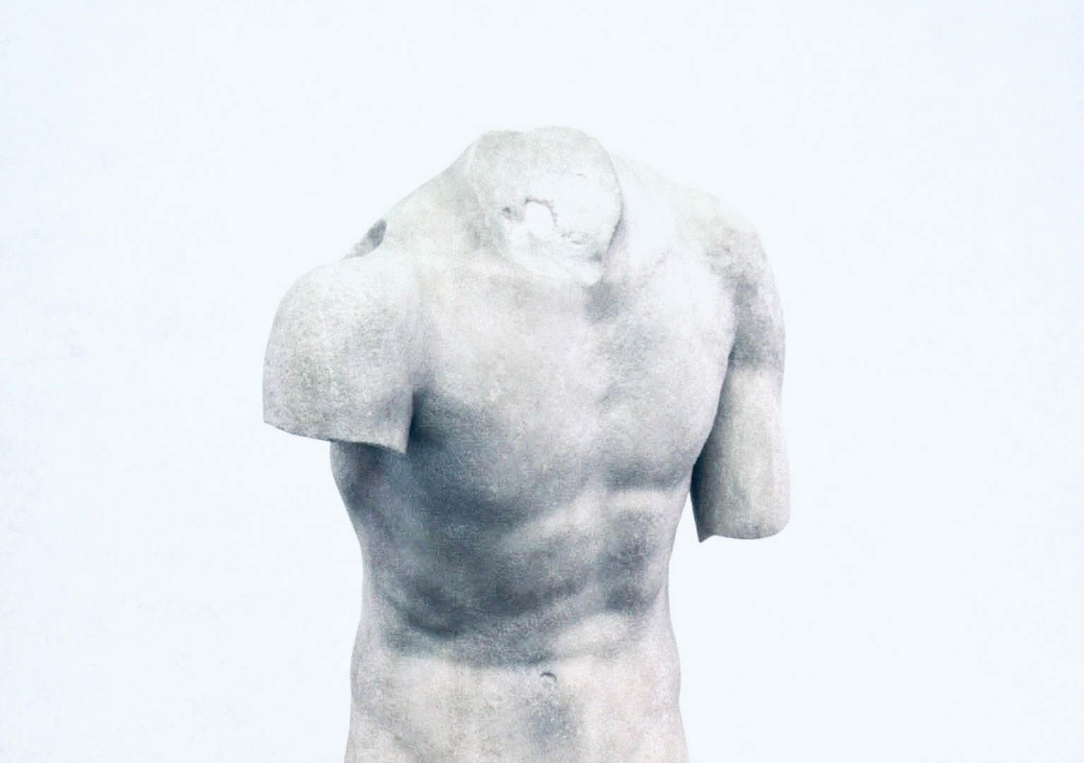 a stone statue of a torso with no head representing headless