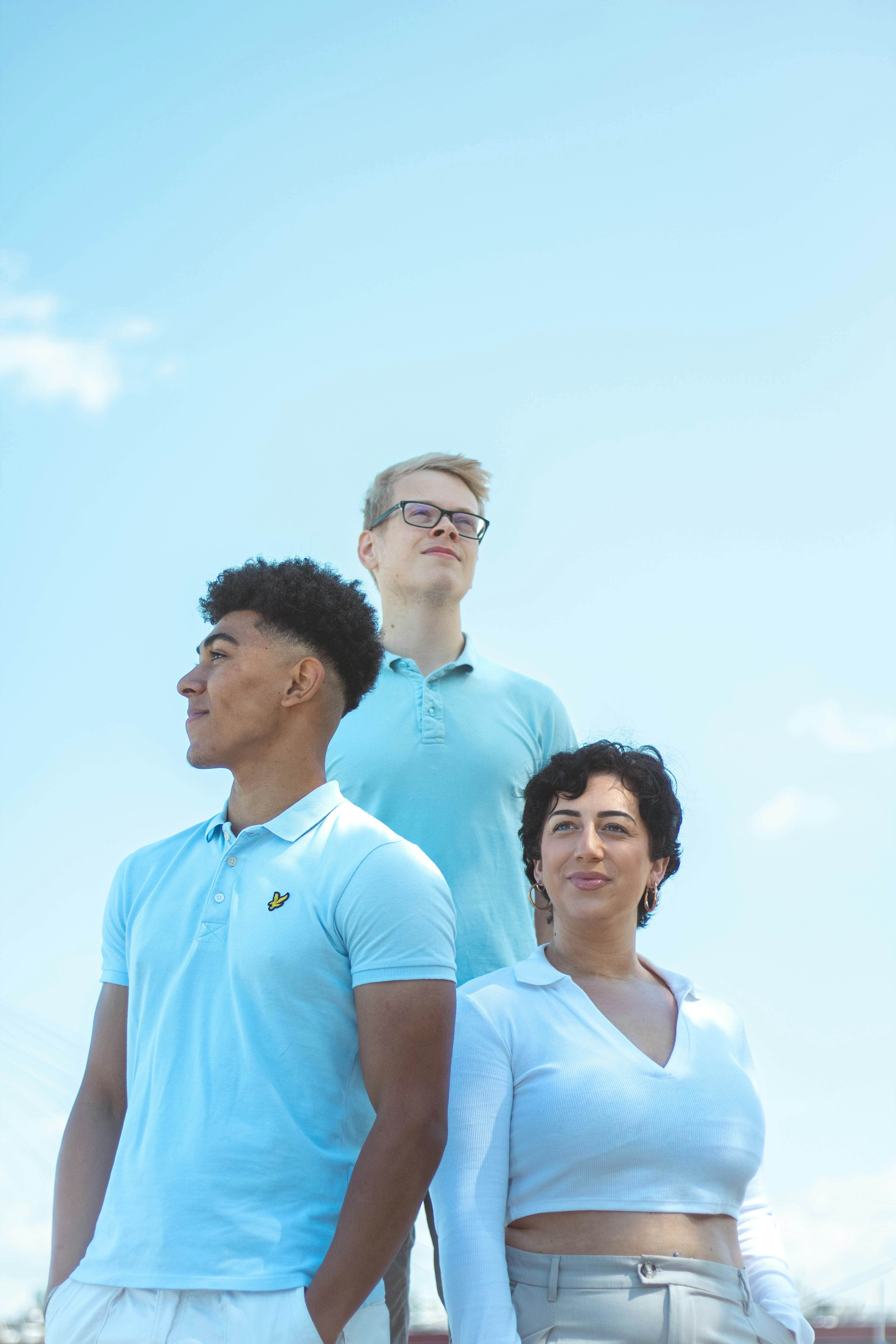 Group photo of three marketeers posing in front of a sunny background