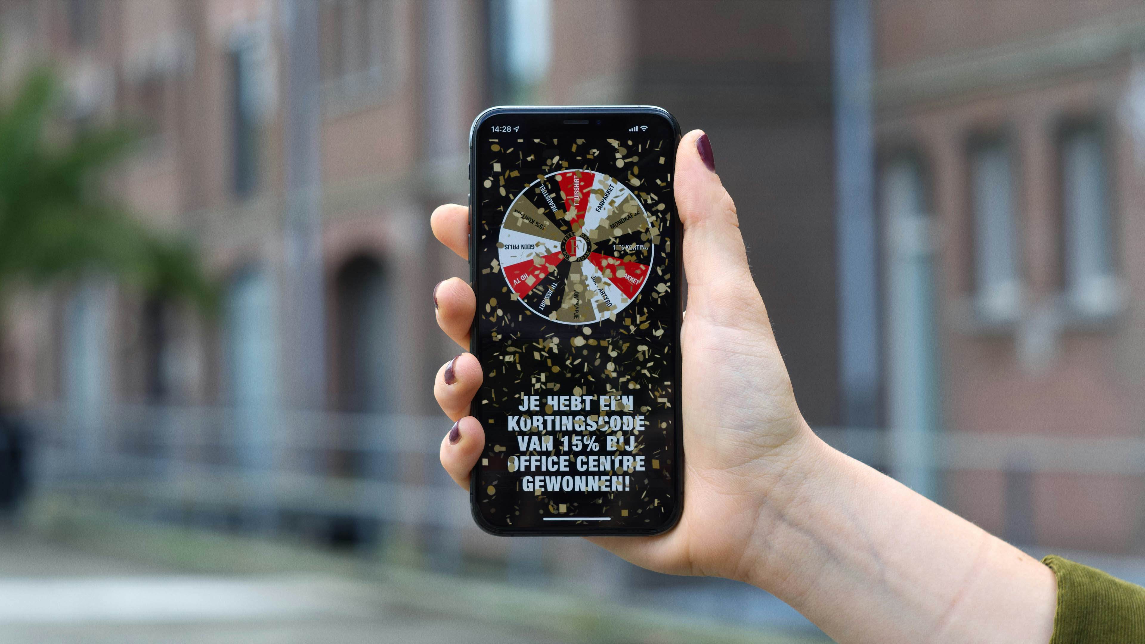 Hand holding a phone with a confetti and a message that price has been won.
