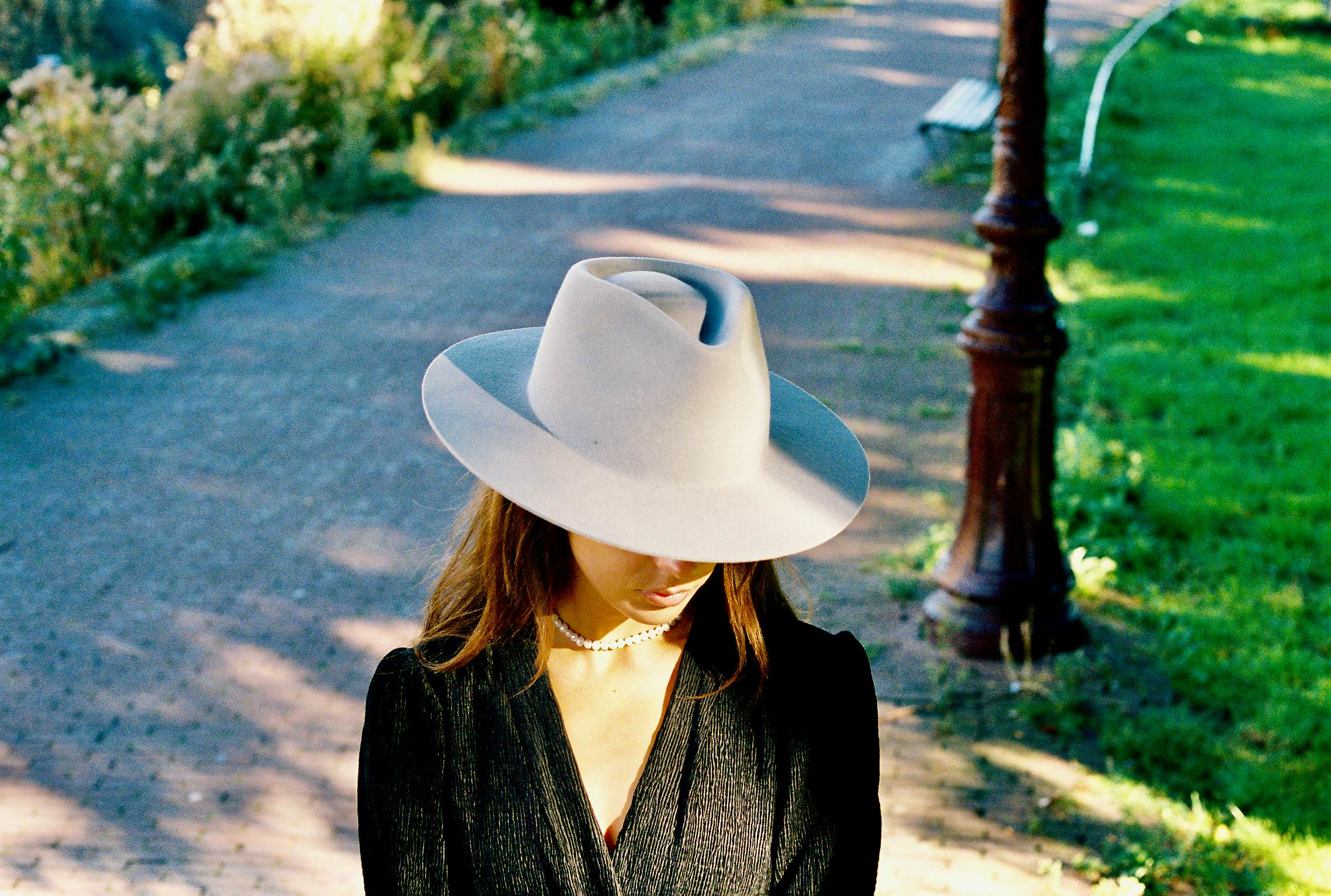 Lady looking down while waring a light blue hat.