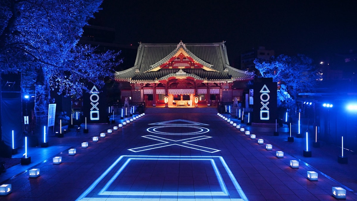 Kanda Myojin shrine in Tokyo illuminated with glowing PlayStation symbols along its approach.