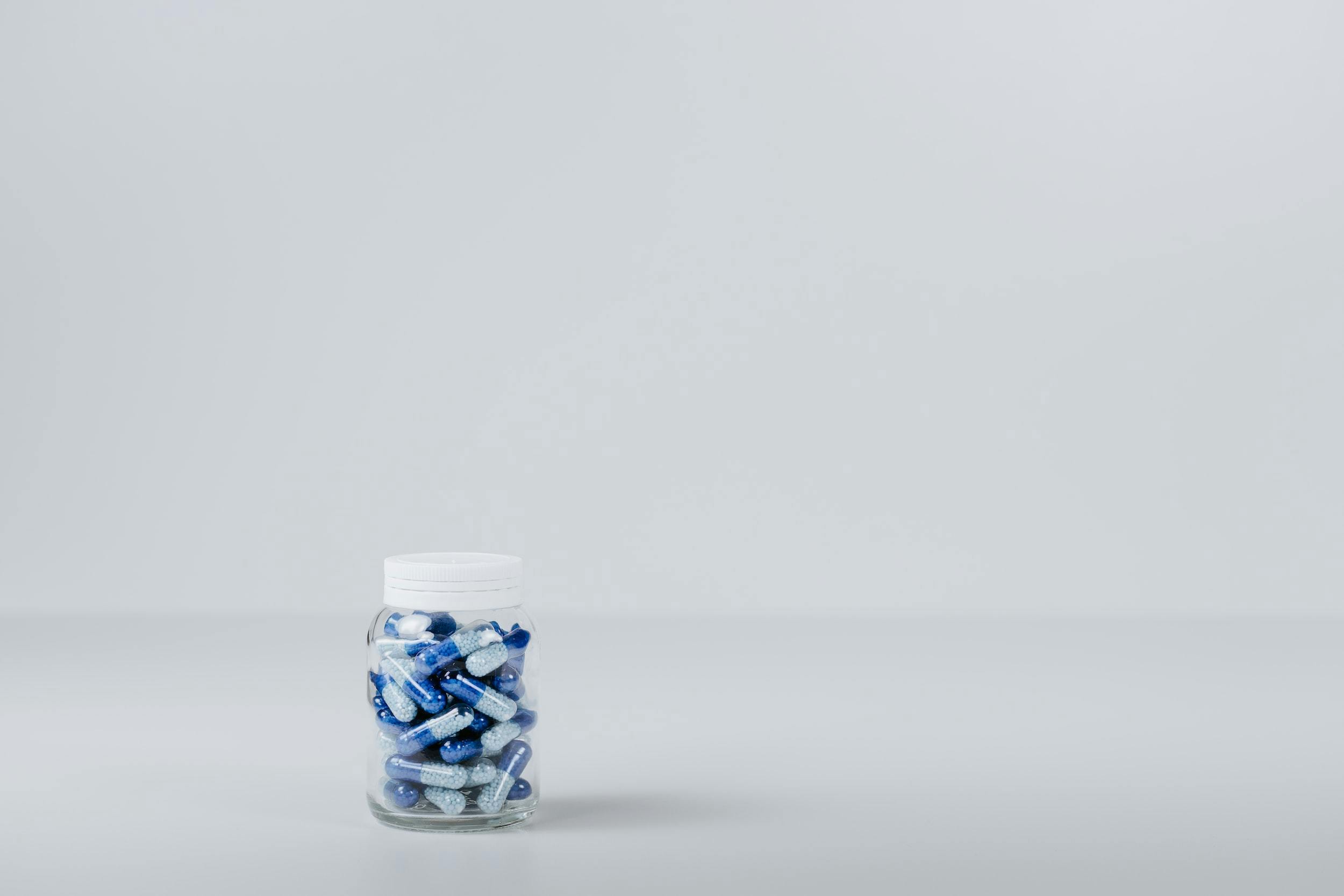 Blue and white tablets in a clear container