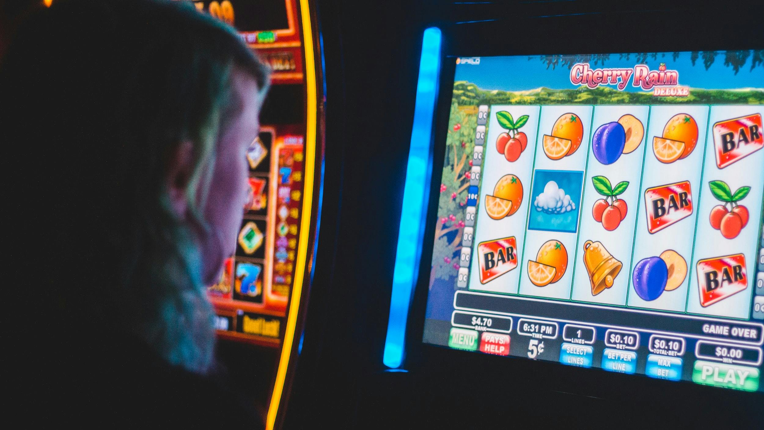 Persona di spalle davanti a una slot machine elettronica accesa