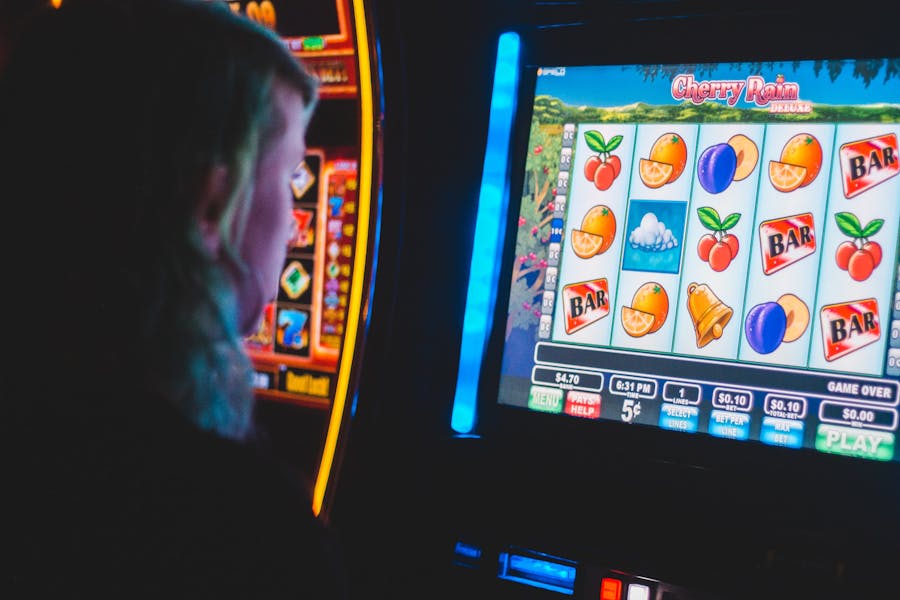 Persona di spalle davanti a una slot machine elettronica accesa