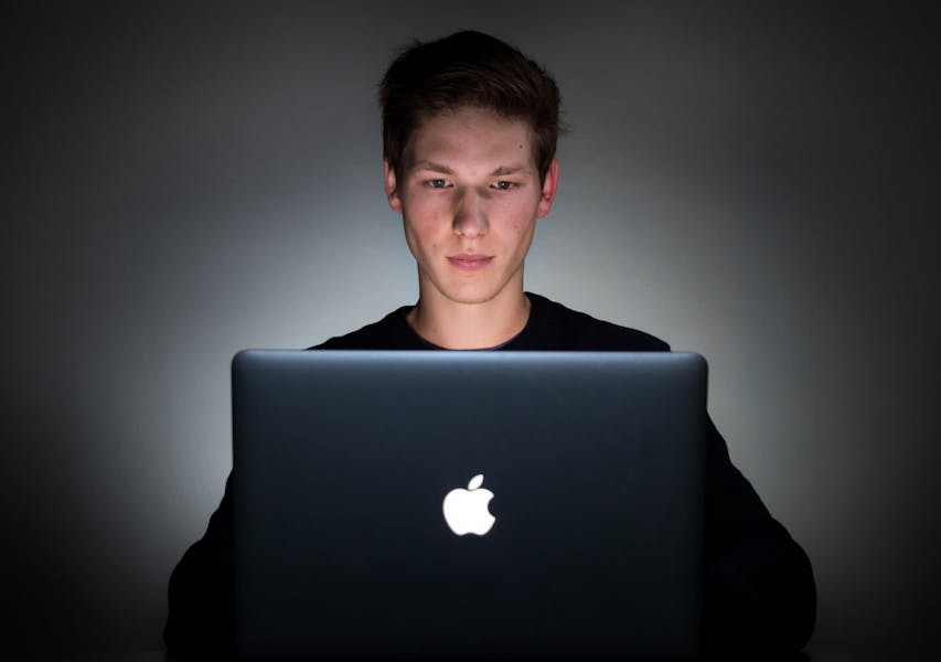 Ragazzo osserva un laptop al buio