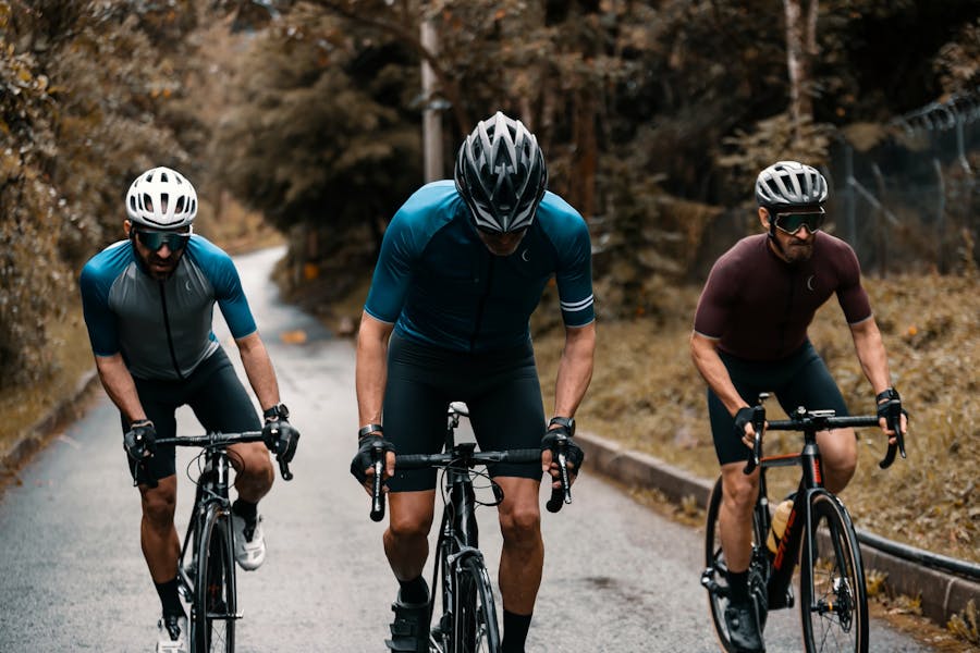 Photo of 3 cyclists pedaling uphill.