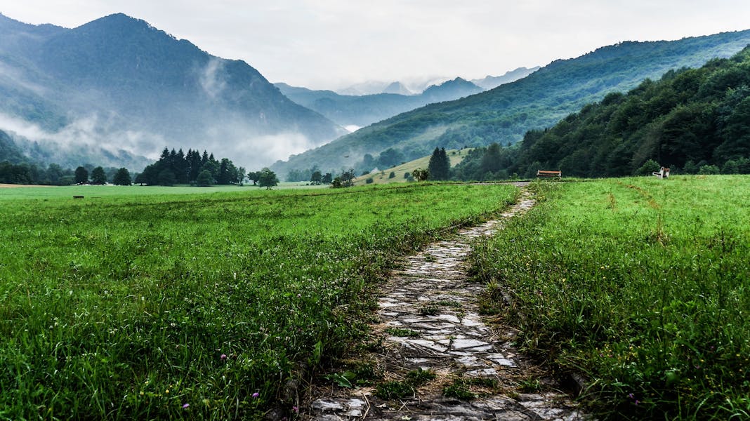 Strada di ciottolato in una vallata verde di giorno