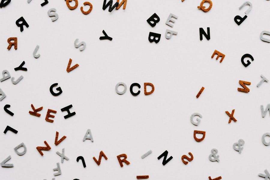 Scattered colored letters on white background forming acronym "OCD".